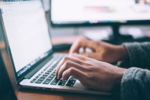 Man typing on a laptop showing only his hands providing good Communication skills within Family business Governance meeting