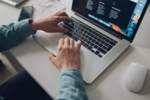 Gentleman using a grey laptop as he Leverages Virtual Platforms in a family business